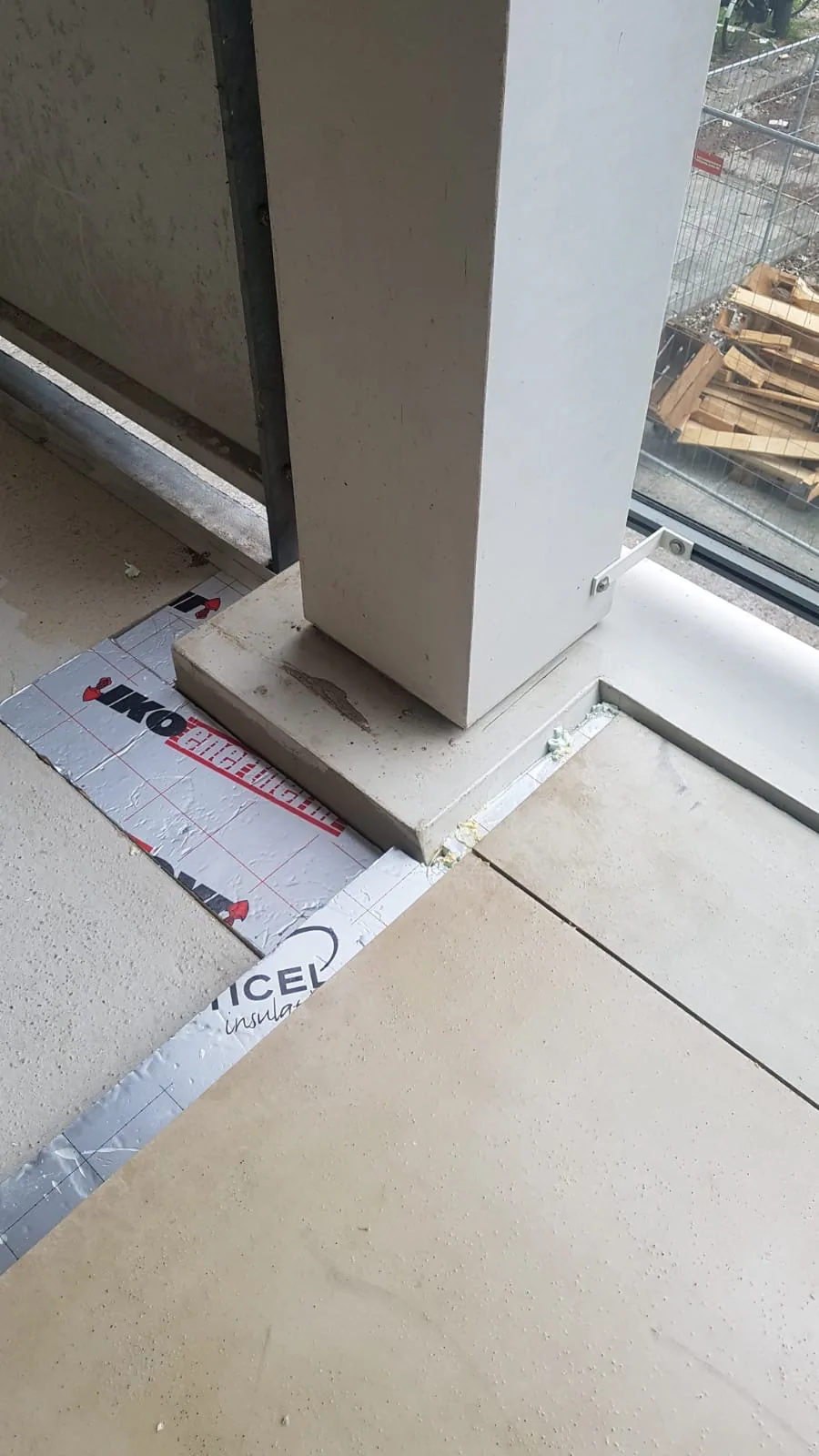 Detail van de vloeropbouw met isolatie en platen rond de voet van een kolom