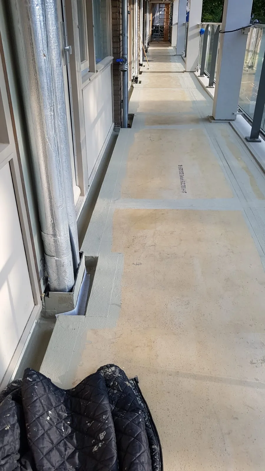 Overzicht van de vloerplaten en aansluitingen langs deuren en leidingen op een galerij