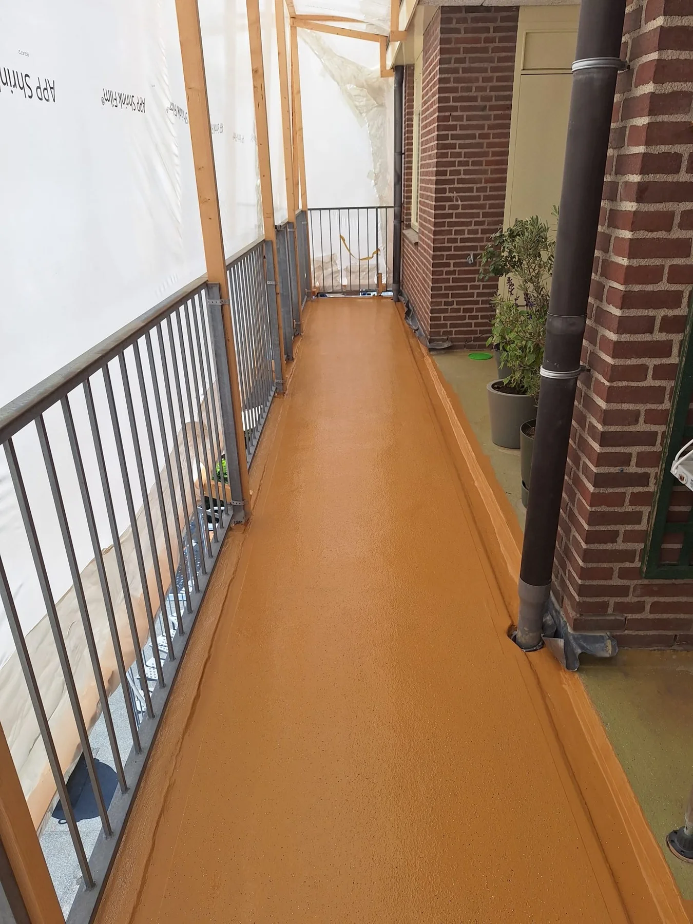 Afgewerkte okerkleurige galerijvloer voor de VvE in Bloemendaal