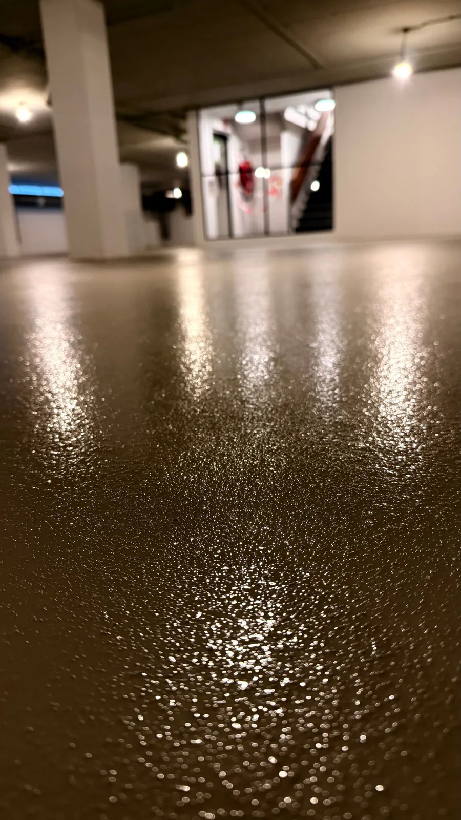 Detail van de vloerafwerking tussen de kolommen van de parkeergarage